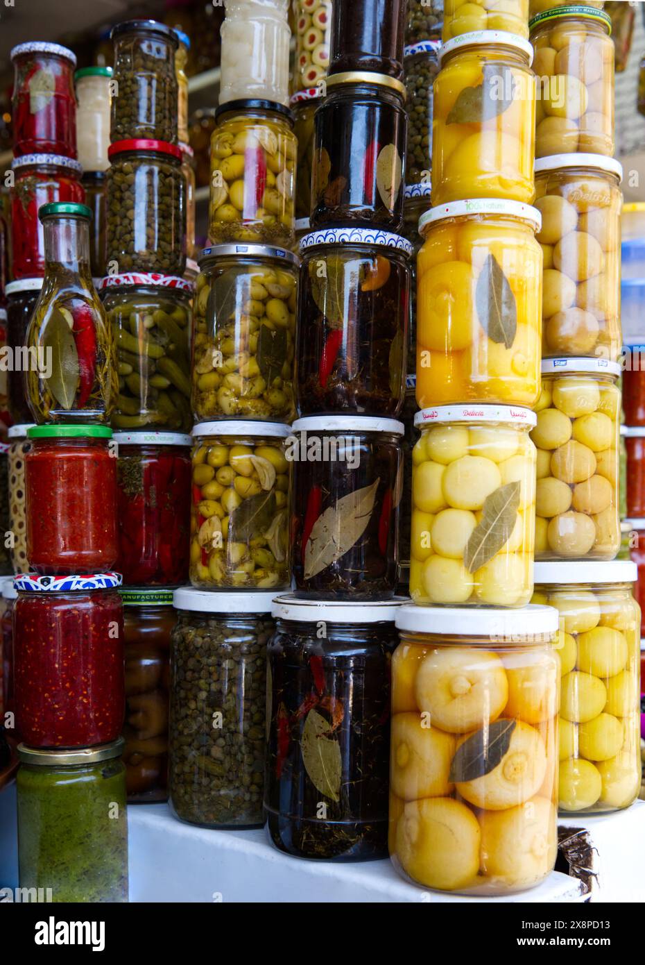 Image d'aliments conservés dans des bocaux empilés verticalement - olives, citrons, oignons, poivrons - dans un marché au Maroc 3 Banque D'Images