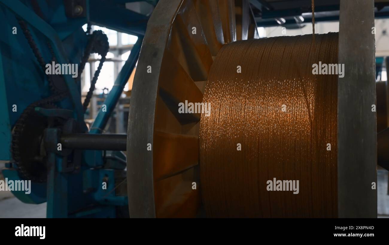 Bobines rotatives avec des fils métalliques à l'usine. Créatif. Enroulement de fibres métalliques sur bobines dans une installation métallurgique. Procédé de torsion en bobines de Banque D'Images