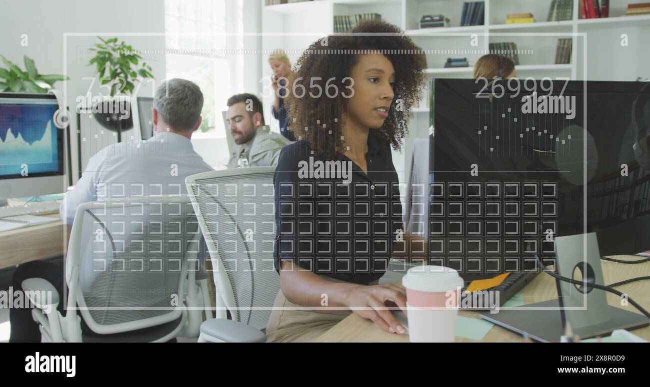 Image de la barre de chargement, des carrés, des nombres changeants, femme biraciale travaillant sur l'ordinateur dans le bureau Banque D'Images