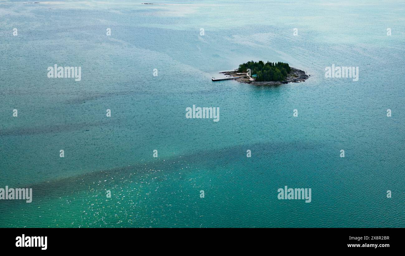 Île éloignée entourée d'eaux bleues claires Banque D'Images