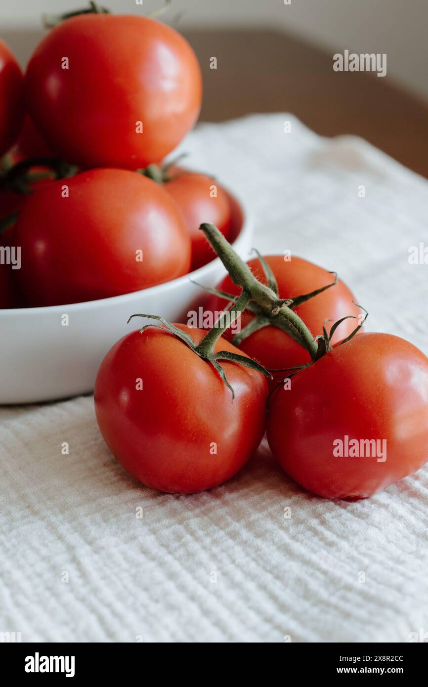 Tomates mûres sur vigne dans un bol blanc Banque D'Images