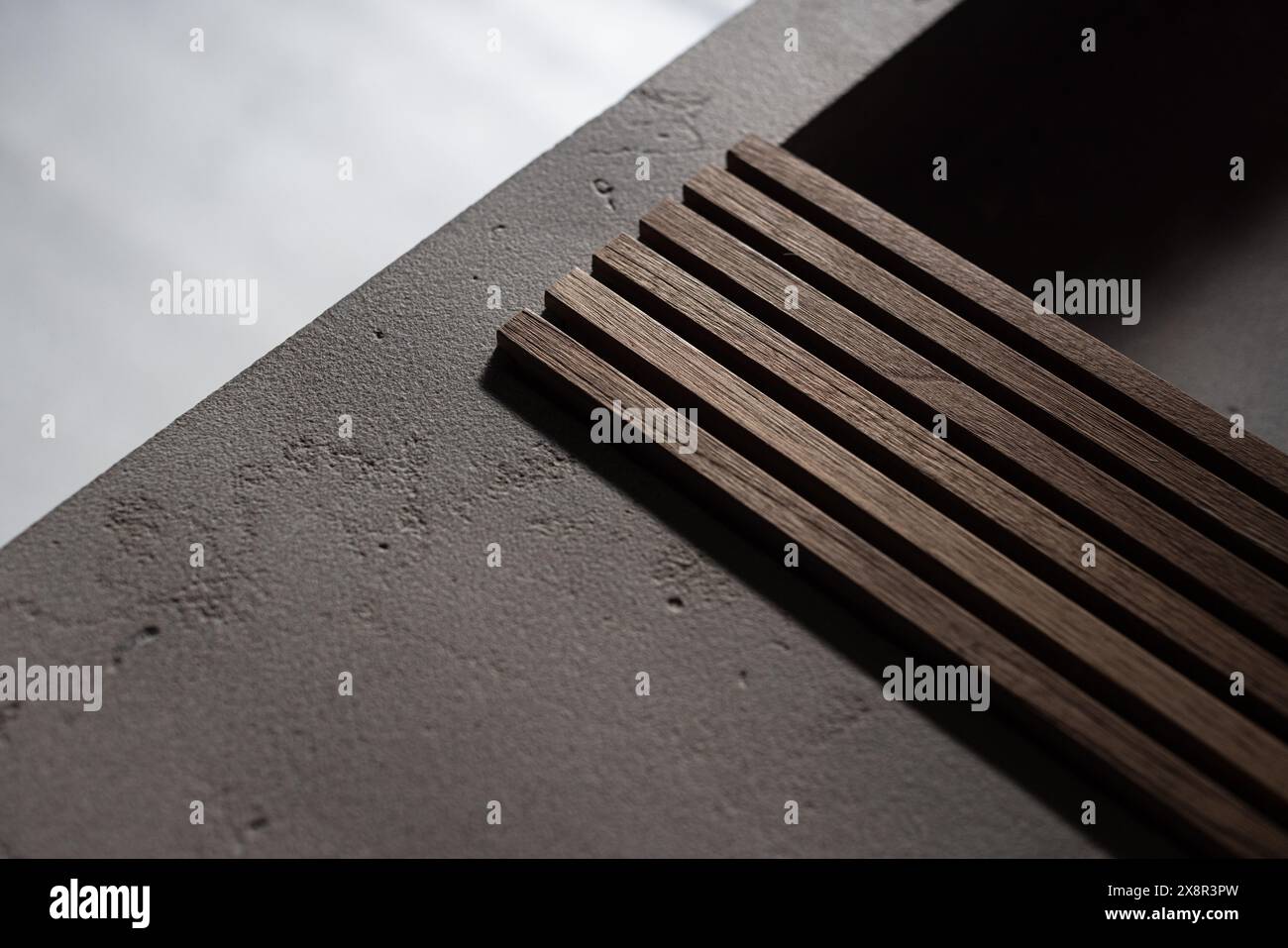 Lattes en bois sur une surface en béton avec un éclairage doux Banque D'Images