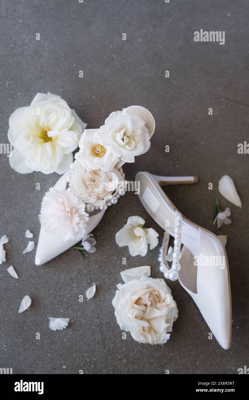 détails de mariage luxueux de talons de mariée blancs disposés avec des fleurs Banque D'Images