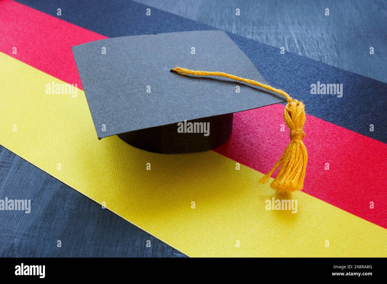 Le chapeau de graduation sur le drapeau allemand comme symbole de l'éducation dans le pays. Banque D'Images