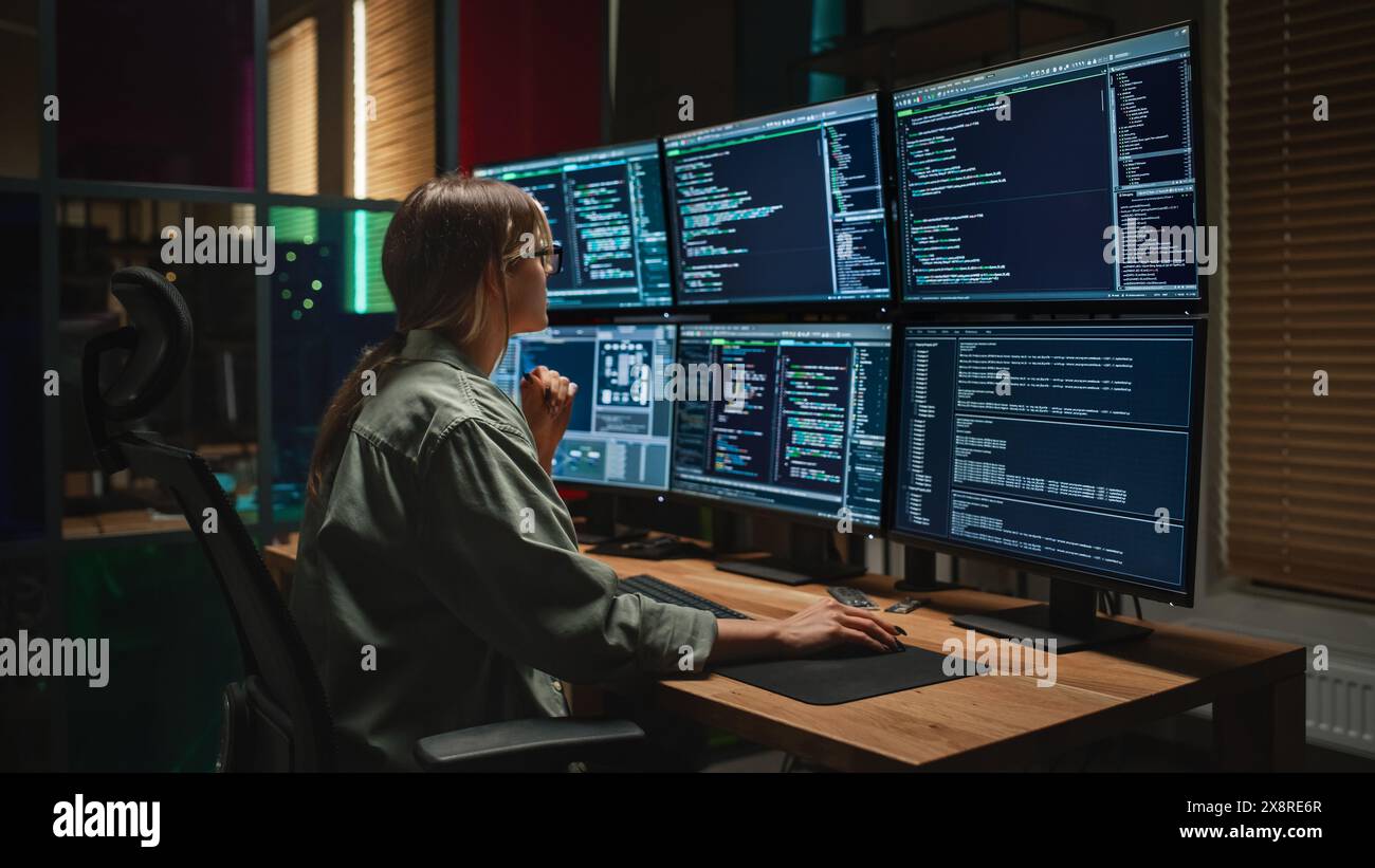 Cyber Security Agency : programmation féminine sur ordinateur de bureau avec six écrans dans Dark Office. Femme caucasienne surveille le système de protection des données, surveille les informations sur les serveurs SAAS. Banque D'Images