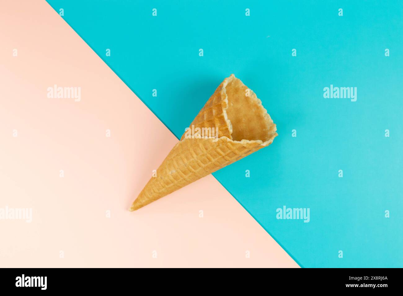 Vue de dessus du cône de gaufre de crème glacée sur fond coloré. Fond d'écran d'été, pose à plat, espace de copie. Banque D'Images