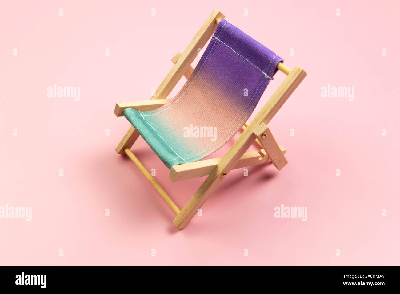 Chaise de plage colorée sur fond rose. Été, vacances et concept de plage. Composition créative, espace de copie. Banque D'Images