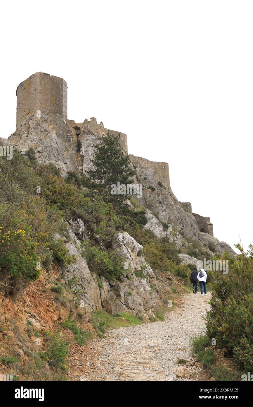 Deux personnes marchant jusqu'au chemin menant au Château Queribus, un ancien château en ruines dans le département de l'Aude, sud de la France Banque D'Images