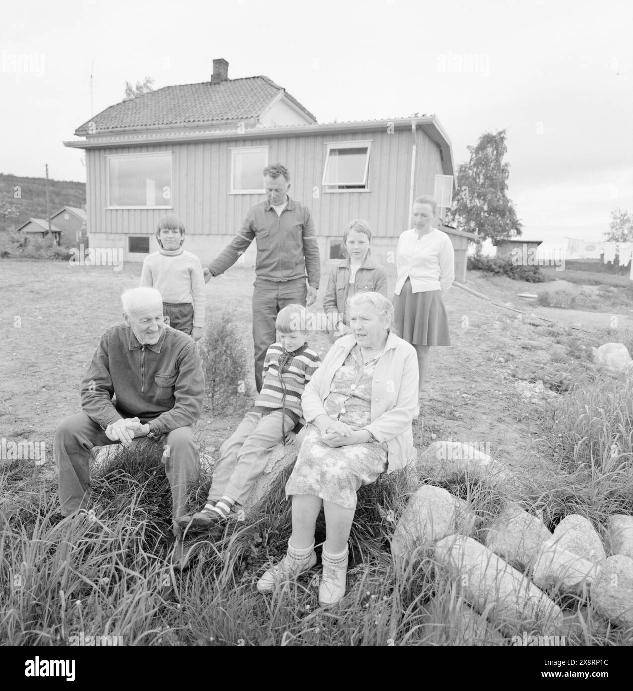 Aktuell 25-6-1973 : I stedet pour gamlehjemNord-Odal viser nye veier i eldreomsorgen. SOM en av landets første kommuner satser man på tregasjonsboliger og skal legge ned aldershjemmet. De eldre skal nå kunne få bo i sitt vante miljø. En samlet kommune står bak generasjonsboligene. De tre generasjonene samlet foran sin bolig som nå er ferdig. Je forgrunnen besteforeldrene Med Rune. Bak Morten og Bente Med foreldrene Oddvin og Berit. Foto : Aage Storløkken / Aktuell / NTB ***FOTO IKKE BILDEBEHANDLET*** cette image est traduite automatiquement Banque D'Images
