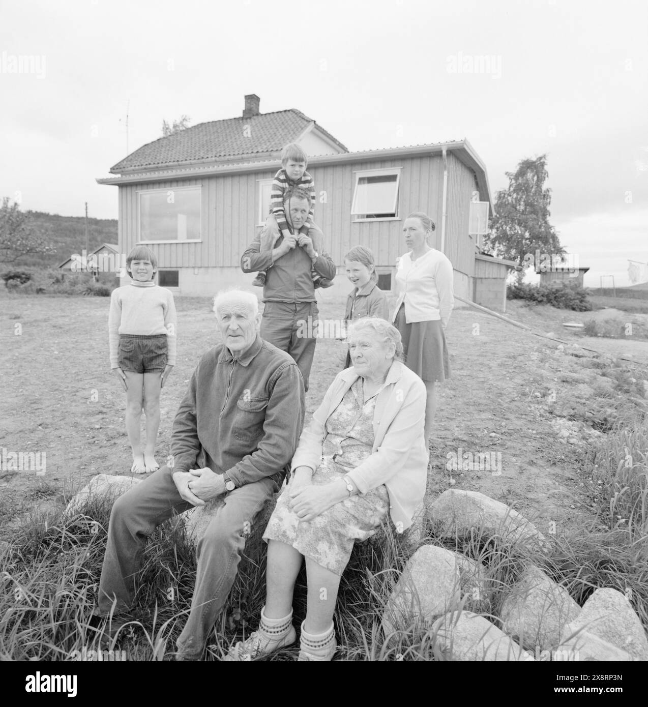 Aktuell 25-6-1973 : I stedet pour gamlehjemNord-Odal viser nye veier i eldreomsorgen. SOM en av landets første kommuner satser man på tregasjonsboliger og skal legge ned aldershjemmet. De eldre skal nå kunne få bo i sitt vante miljø. En samlet kommune står bak generasjonsboligene. De tre generasjonene samlet foran sin bolig som nå er ferdig. Je forgrunnen besteforeldrene Med Rune. Bak Morten og Bente Med foreldrene Oddvin og Berit. Foto : Aage Storløkken / Aktuell / NTB ***FOTO IKKE BILDEBEHANDLET*** cette image est traduite automatiquement Banque D'Images