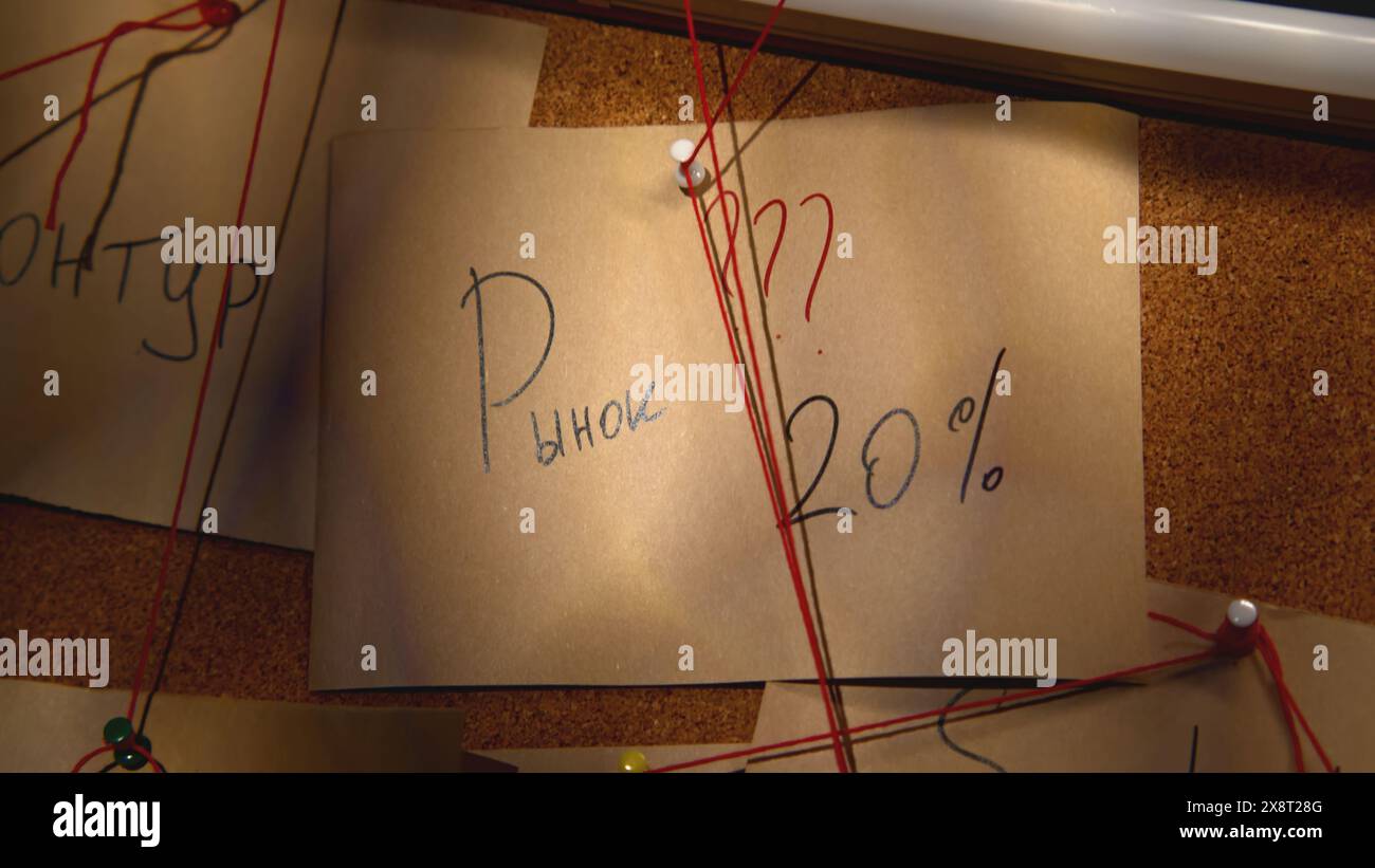 Notes avec fil rouge sur le tableau d'idées. Film de stock. Notes en gros plan avec inscriptions à bord avec rebus. Mystérieux tableau noir avec des notes et du rouge Banque D'Images