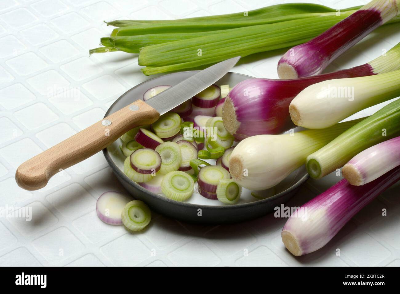 Oignons blancs et violets et tranches d'oignon dans leurs peaux, oignon de printemps Banque D'Images