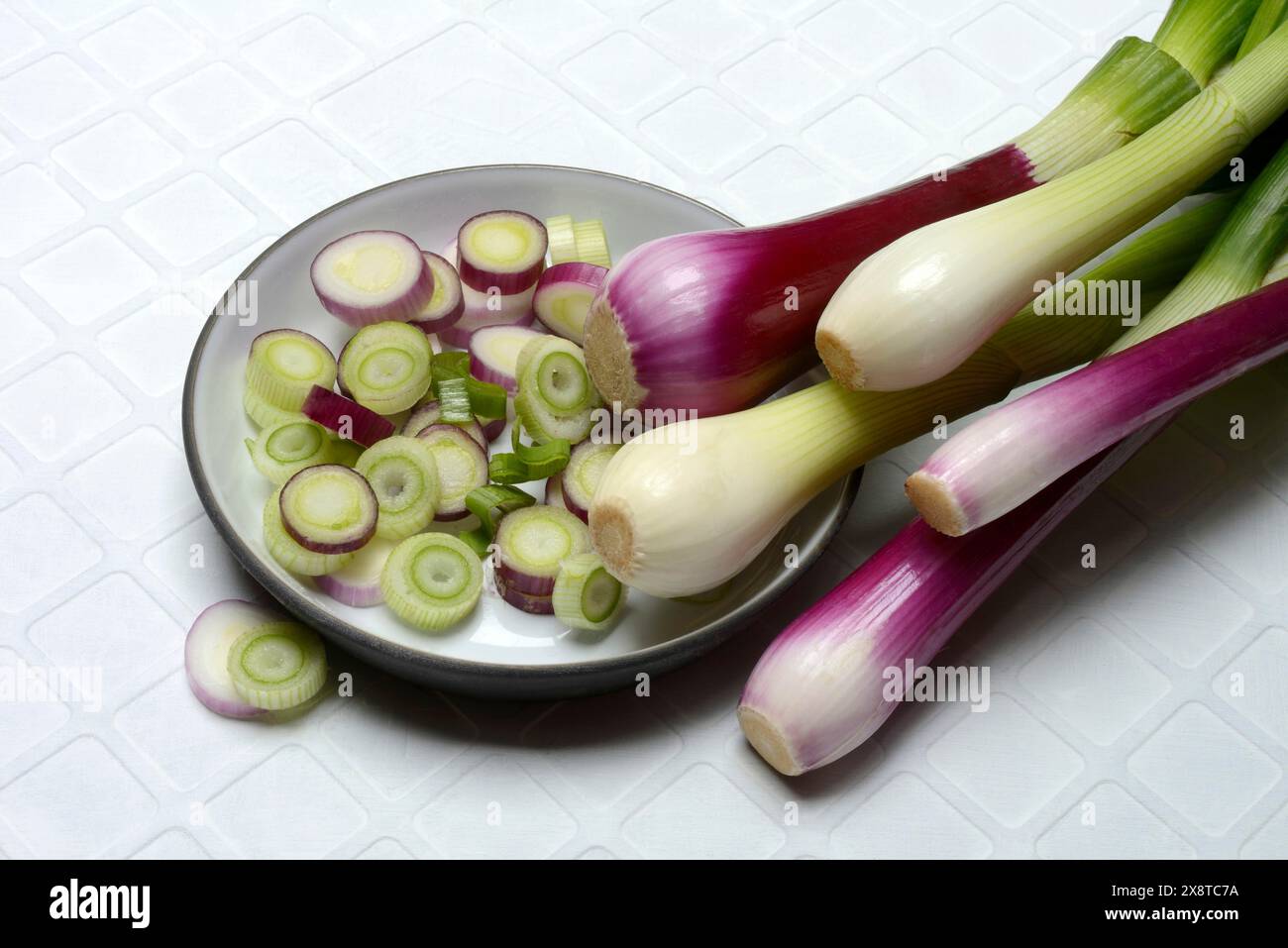 Oignons blancs et violets et tranches d'oignon dans leurs peaux, oignon de printemps Banque D'Images