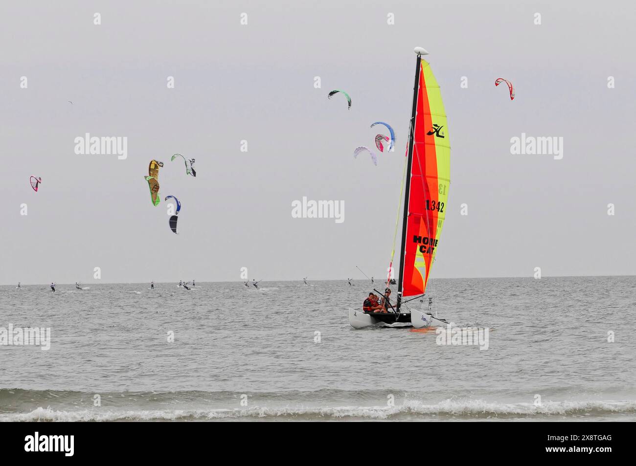 Coupe du monde de kitesurf 2009, Sankt Peter-Ording, Nordfriesland, Schleswig-Holstein, Allemagne, Europe, Un catamaran coloré navigue sur la mer tandis que plusieurs Banque D'Images