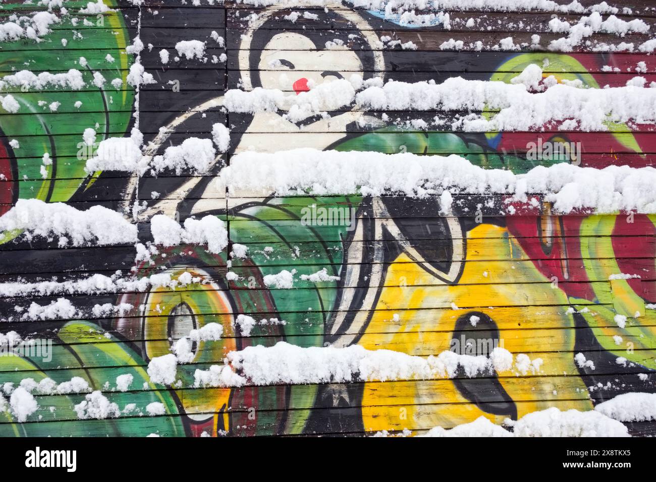 Graffiti enneigé dans une chute de neige printanière, Uus Maailm (Nouveau monde), un sous-district de Kesklinn (centre-ville), Tallinn, Estonie. Banque D'Images