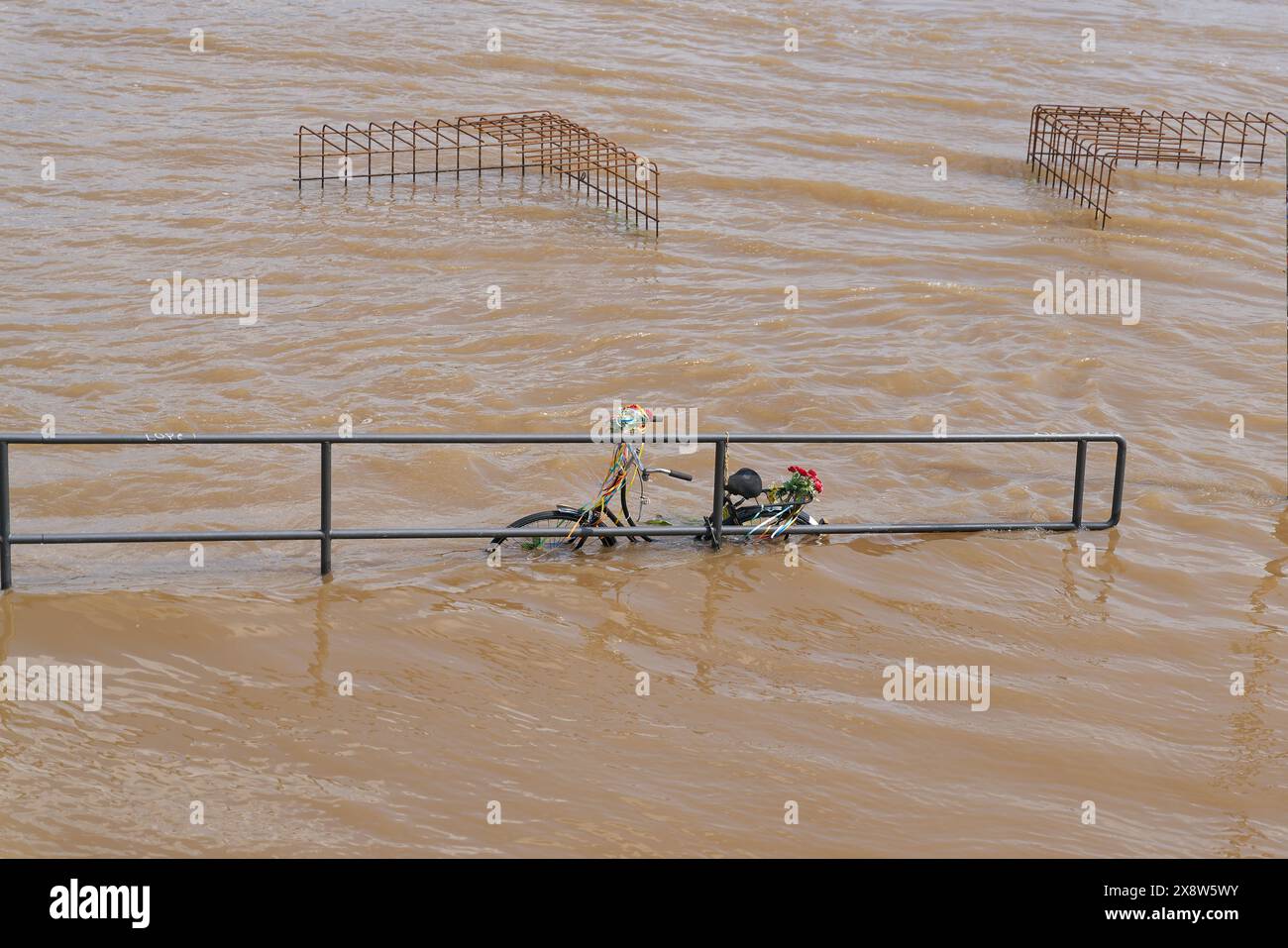 Promenade inondée le long du Rhin à Cologne en Allemagne avec un vélo oublié sur une rampe Banque D'Images