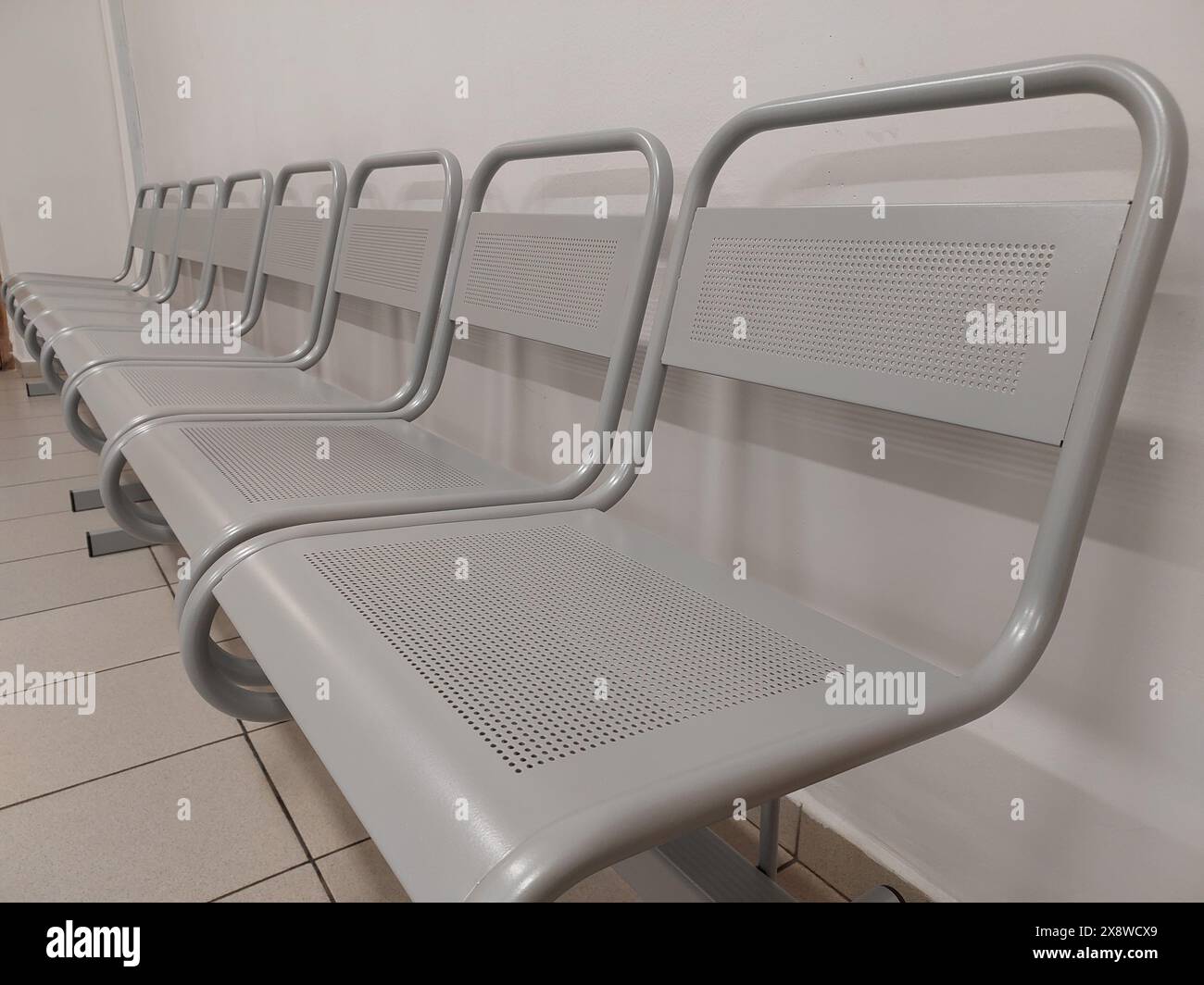 Une rangée de chaises grises en métal vides dans le bureau. Concept : pas de clients, pas de files d'attente. Foyer sélectionné. Banque D'Images