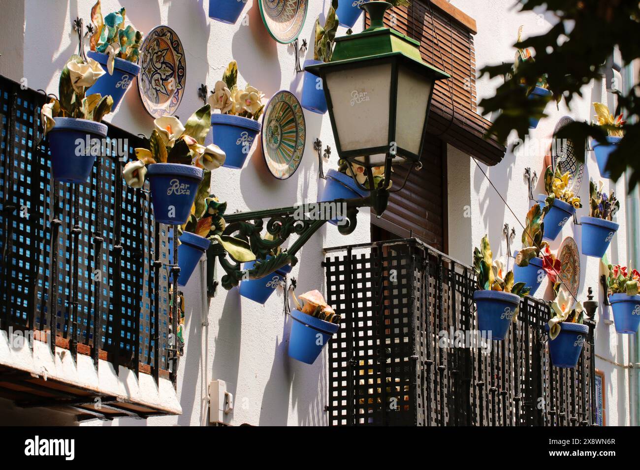 Des pots de plantes colorés décorent l'extérieur d'une maison de ville typique en Espagne Banque D'Images