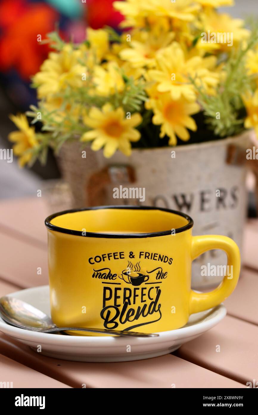 Une tasse à café jaune vif se trouve sur une table extérieure, Cadix, Espagne Banque D'Images