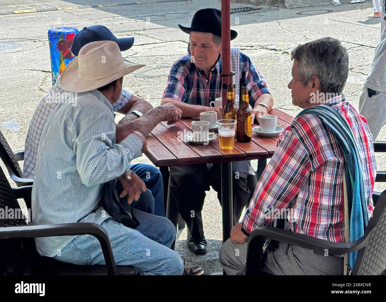 Les hommes de la région apprécient un repas sur la place principale de Filandia, en Colombie Banque D'Images