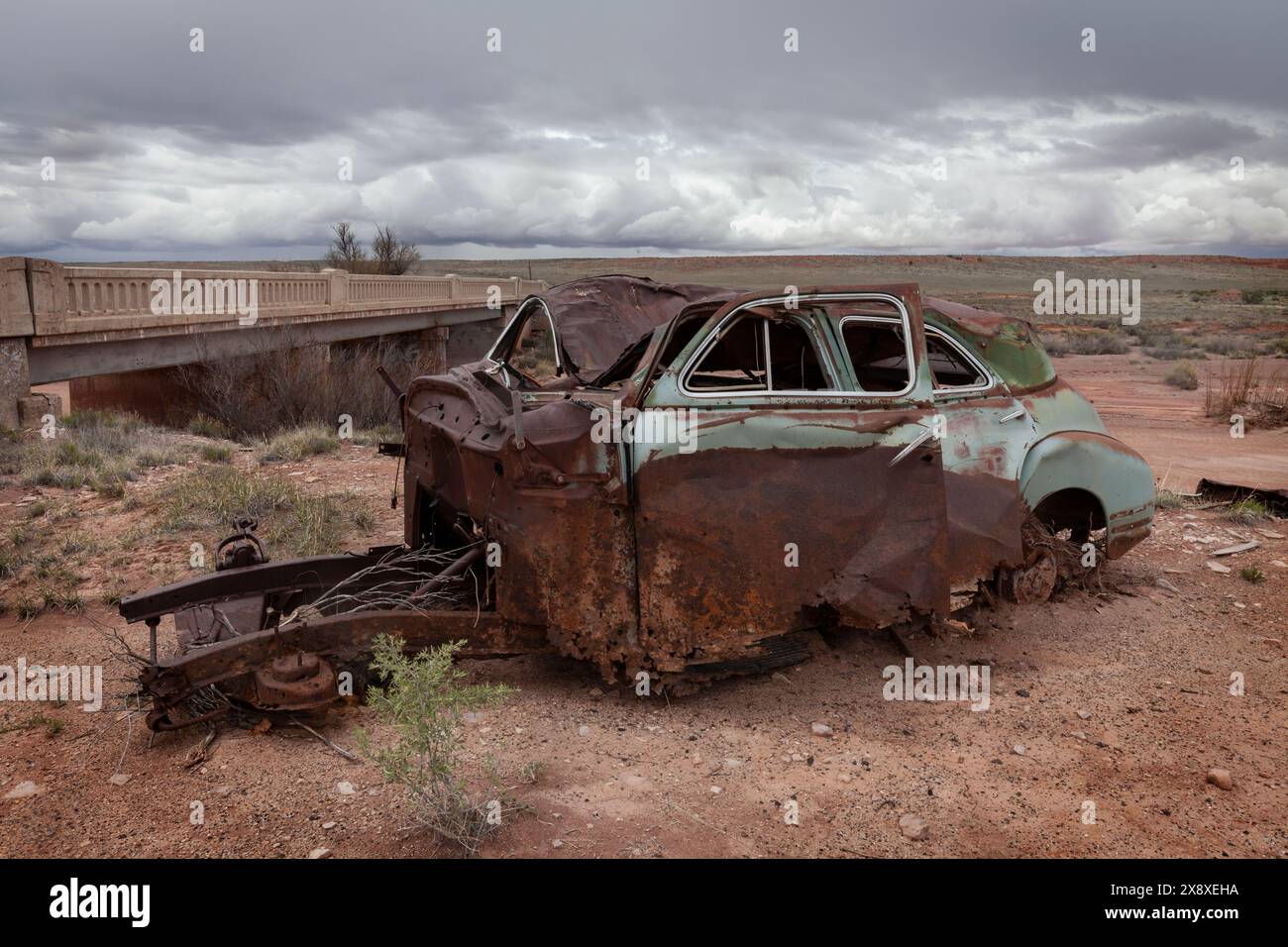 Un coupé rouillé des années 1940 se trouve sur la rive du Dead Wash à côté d'un pont de la route 66 près du Painted Desert en Arizona. Banque D'Images