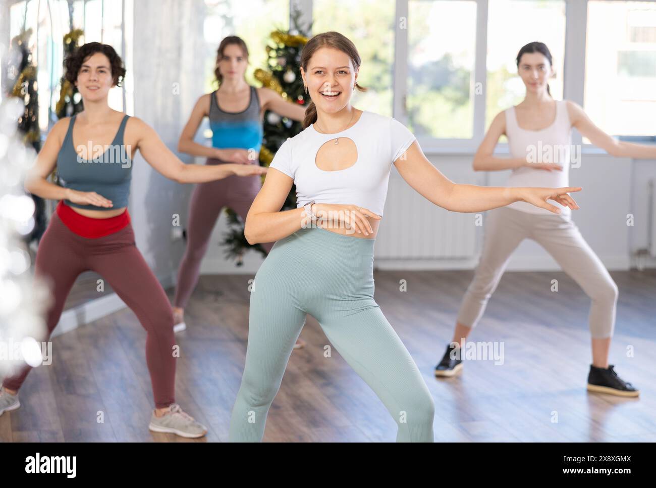 Jeune femme joyeuse participant à un entraînement de danse énergique pendant la saison de Noël Banque D'Images