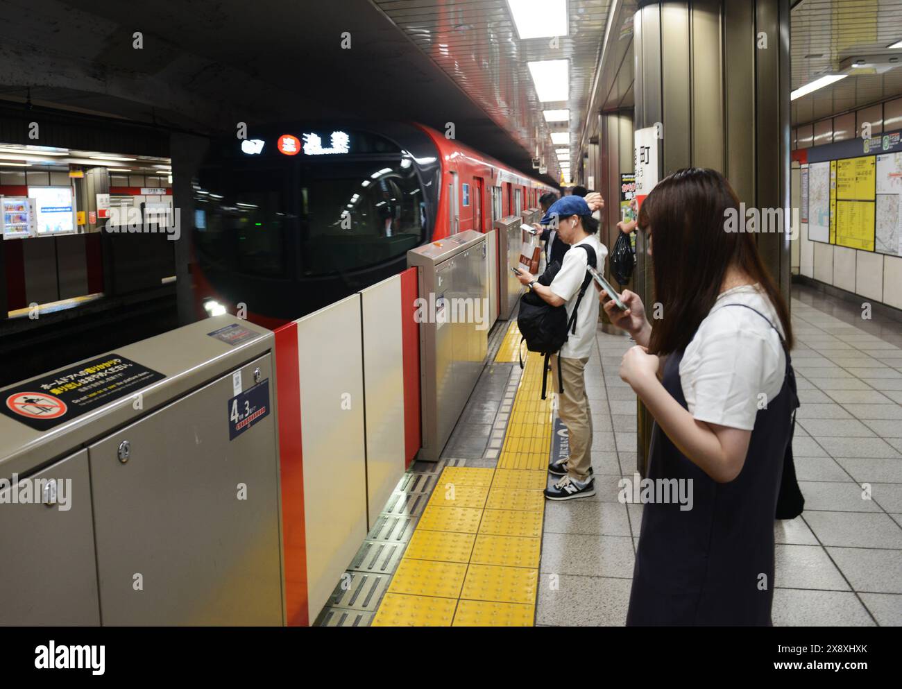 Passagers attendant le train de métro pour Ikebukuro à la gare Jimbocho de Kanda, Tokyo, Japon. Banque D'Images