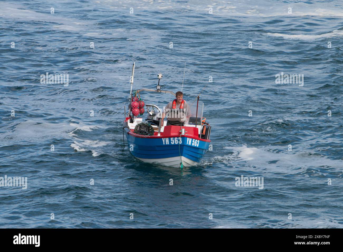 Petit bateau ouvert avec un seul pêcheur et ramasser des pots de crabe. Cornwall. ROYAUME-UNI 2024 Banque D'Images