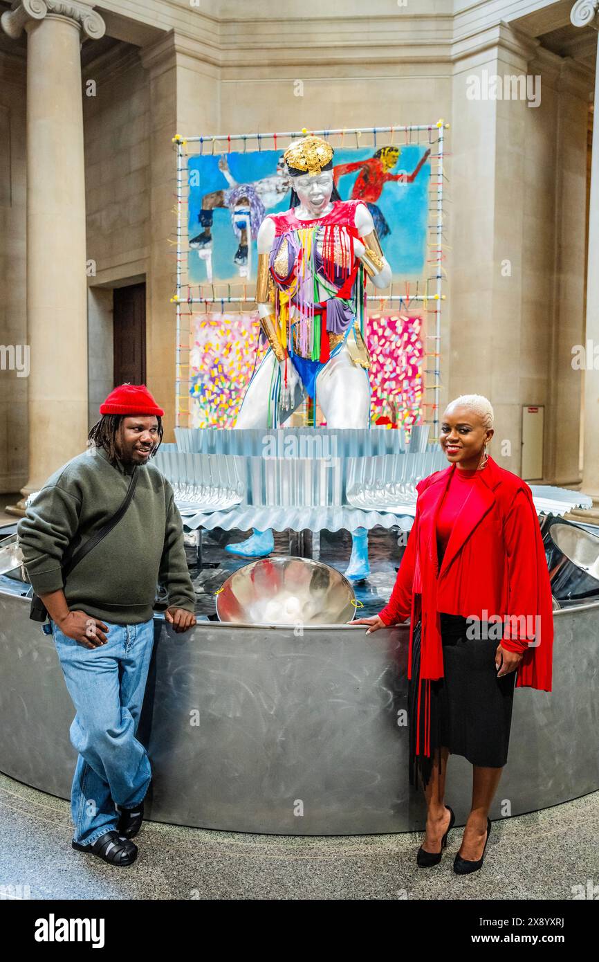 Londres, Royaume-Uni. 28 mai 2024. Grace, 2024, Une nouvelle commande de l'artiste Alvaro Barrington (photographiée avec la sculpture de Samantha et Samantha Harrison, le modèle) dans les galeries néo-classiques Duveen de la Tate Britain. Se considérant avant tout comme un peintre, Barrington est connu pour son utilisation étendue de matériaux, de motifs et de techniques qui font référence à ses souvenirs personnels et à ses influences culturelles de la musique, de la culture pop et de l'histoire de l'art. Crédit : Guy Bell/Alamy Live News Banque D'Images