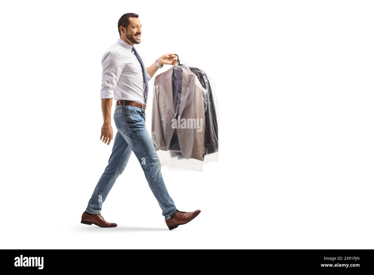 Plan de profil pleine longueur d'un homme portant des costumes sur des cintres avec un sac de nettoyage à sec en plastique isolé sur un fond blanc Banque D'Images