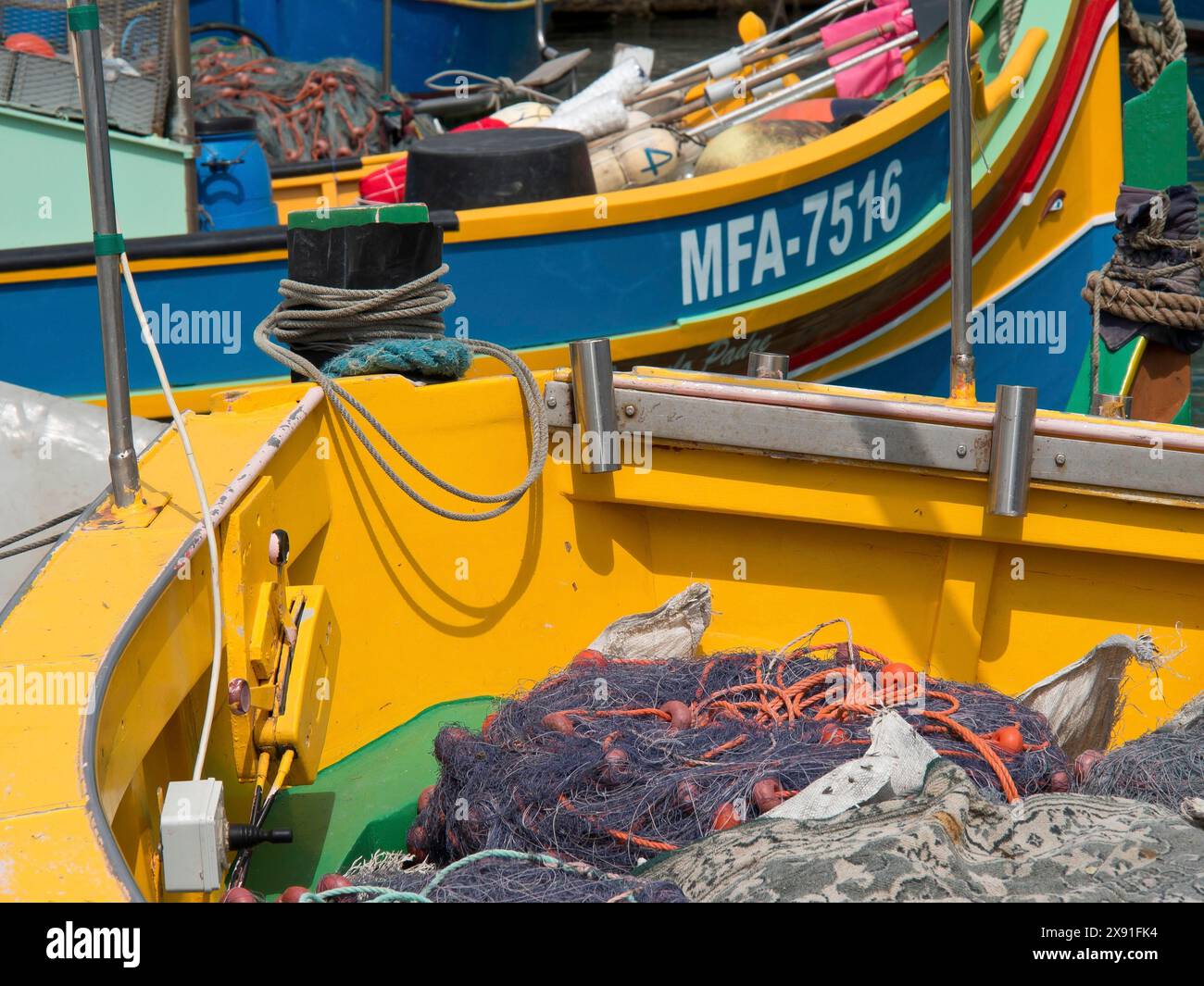 Gros plan de bateaux colorés dans le port, chargés de filets de pêche, bateaux colorés dans un port historique sur la Méditerranée, Marsaxlokk, malte Banque D'Images