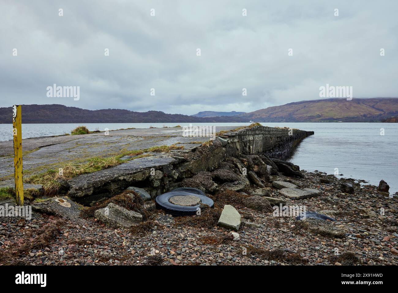 Un après-midi froid de février et un pneu mis au rebut et des morceaux de béton brisé jonchent la plage de Bonawe Pier près de Taynuilt Jetty Banque D'Images