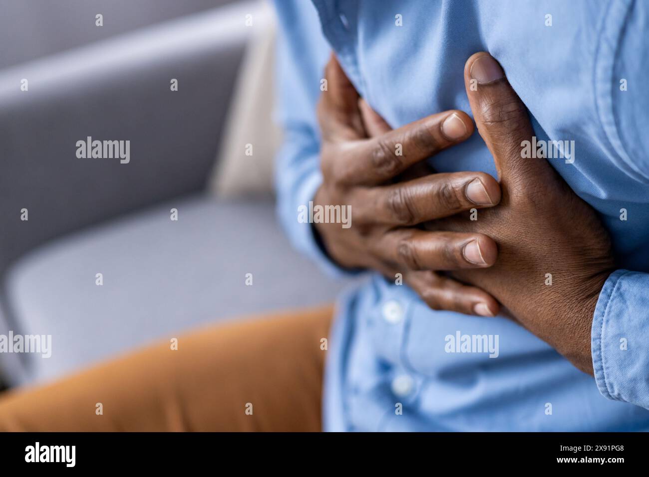 Gros plan d'une personne serrant sa poitrine, indiquant une douleur cardiaque ou un stress possible. Consulter immédiatement un médecin pour de tels symptômes afin de répondre à des problèmes de santé et des urgences Banque D'Images