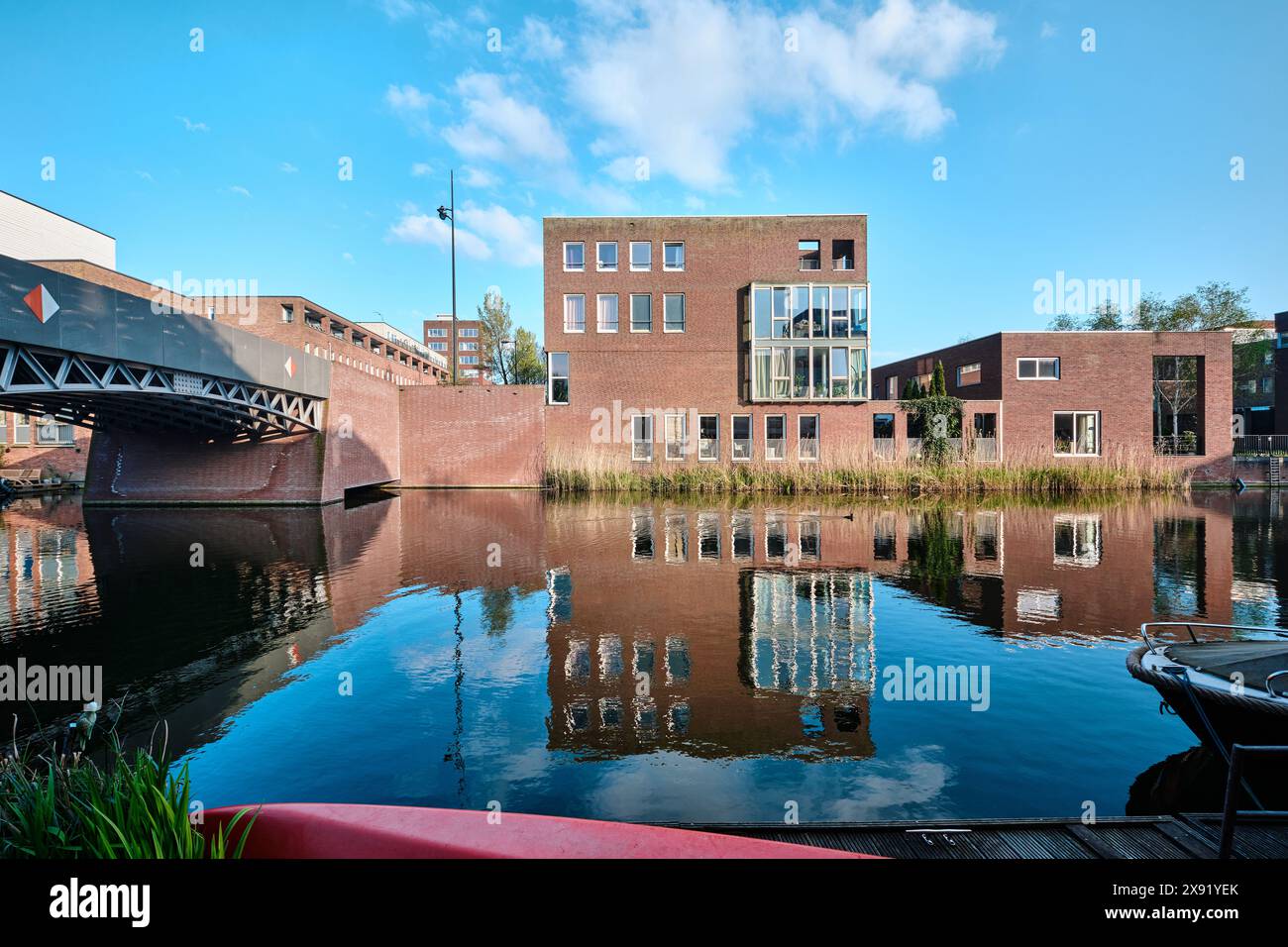 Pays-Bas, Amsterdam - 10 avril 2024 : bâtiments résidentiels et architecture moderne en briques avec vue sur le canal dans le district d'Ijburg Banque D'Images