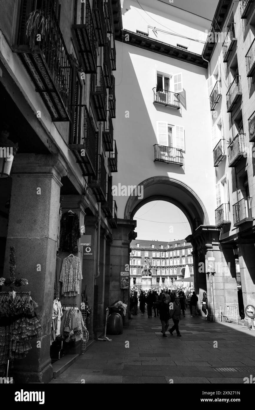 Madrid, Espagne- 7 avril 2024 : belle rue avec arcade et la place Plaza Mayor en arrière-plan sur une journée ensoleillée du printemps Banque D'Images