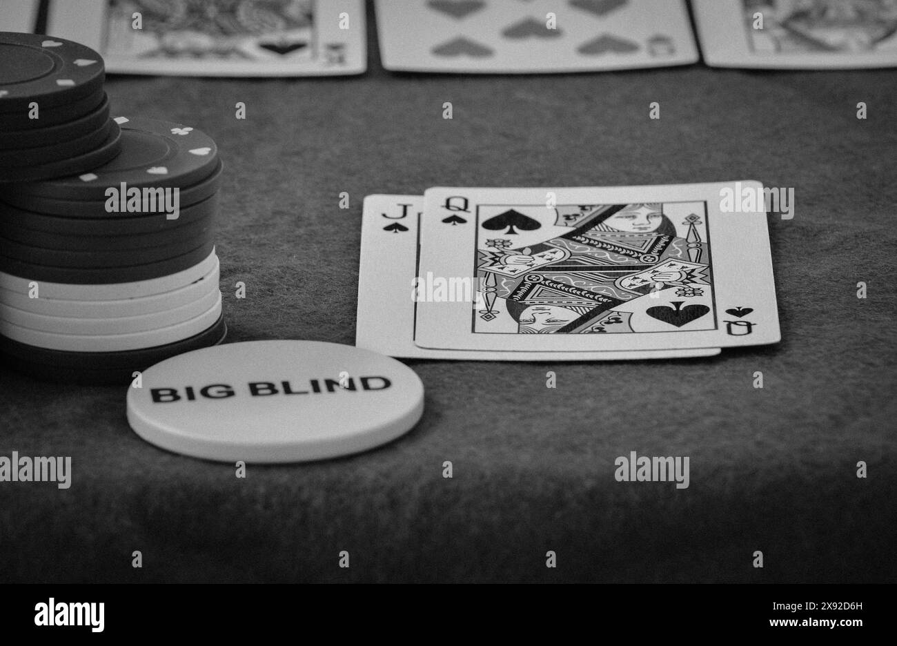 Texas Hold'em main de poker, reine de pique et jack de pique avec grand bouton blind Banque D'Images