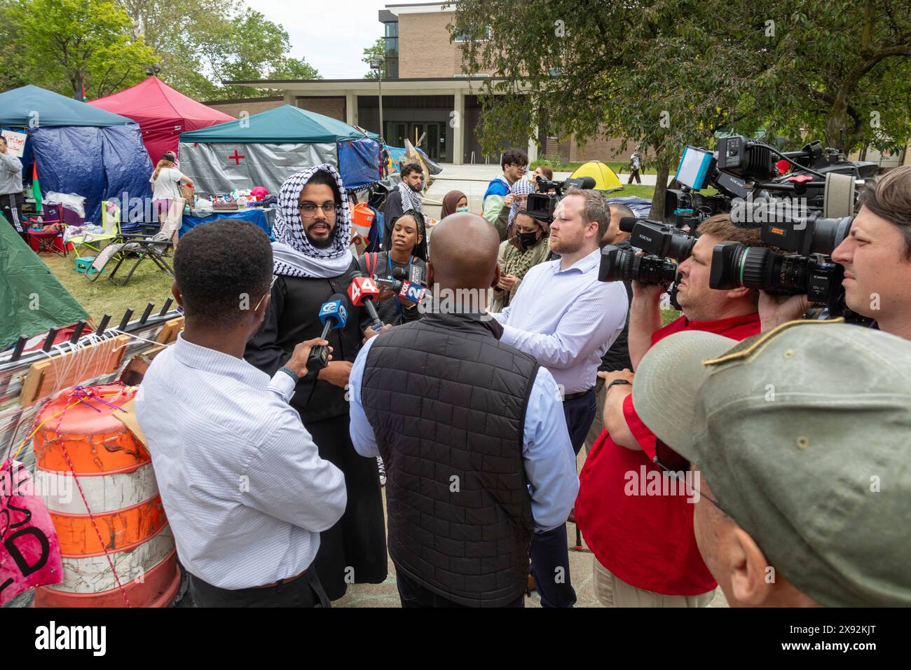 Detroit, Michigan, États-Unis. 28 mai 2024. Un campement de tentes installé par des étudiants de l’Université d’État Wayne en solidarité avec les victimes des bombardements israéliens à Gaza. L'université a répondu en annulant les cours 'jusqu'à nouvel ordre'. Ali Hassan, président de la Coalition musulmane de l’UMS, s’adresse aux journalistes du camp. Crédit : Jim West/Alamy Live News Banque D'Images