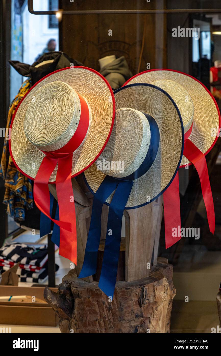 Chapeaux rouges et bleus de gondolier vénitien suspendus à une cheville. Banque D'Images