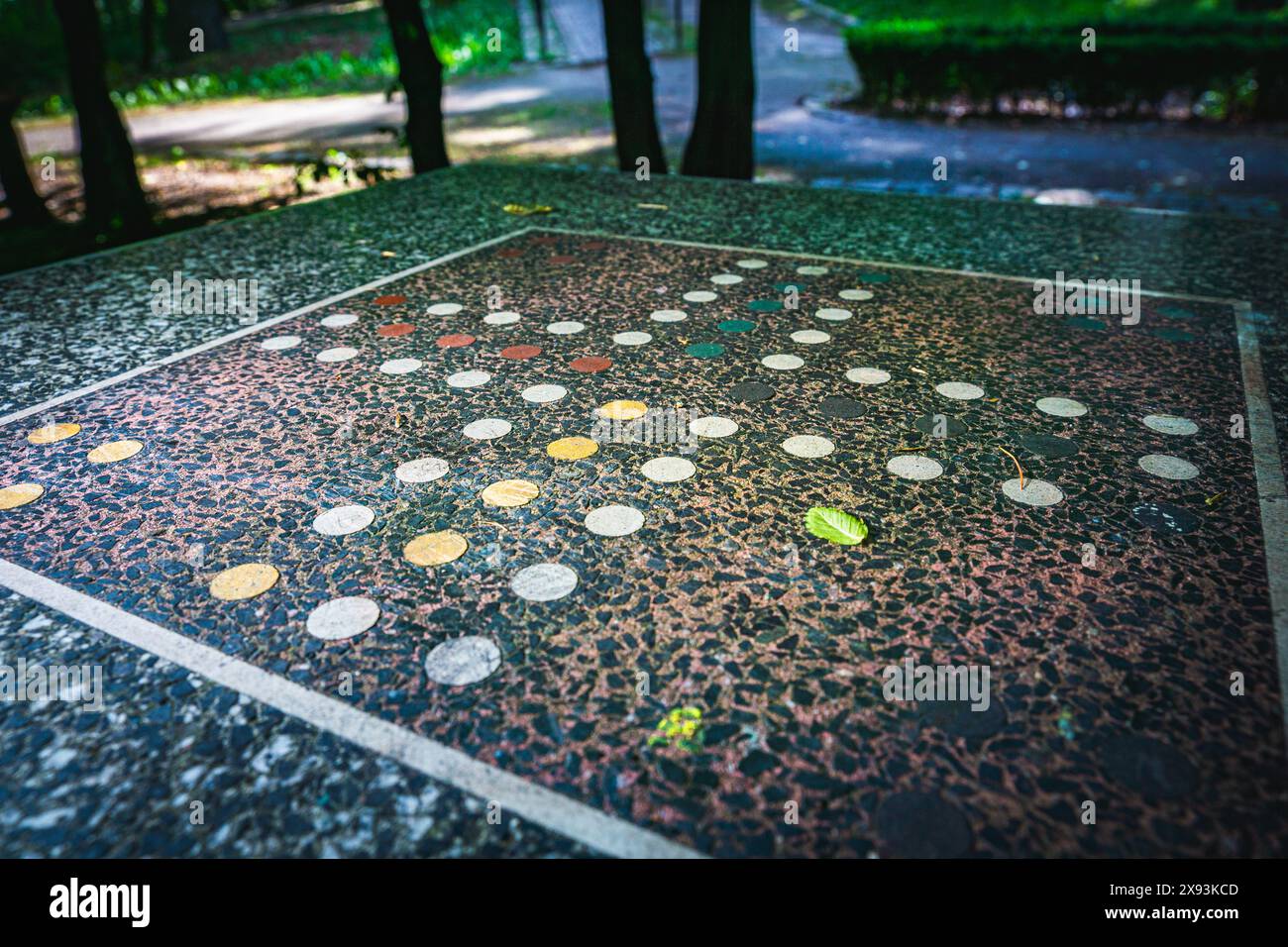 Une vue rapprochée d'un plateau de jeu installé au milieu d'un parc, entouré de verdure et d'arbres Banque D'Images