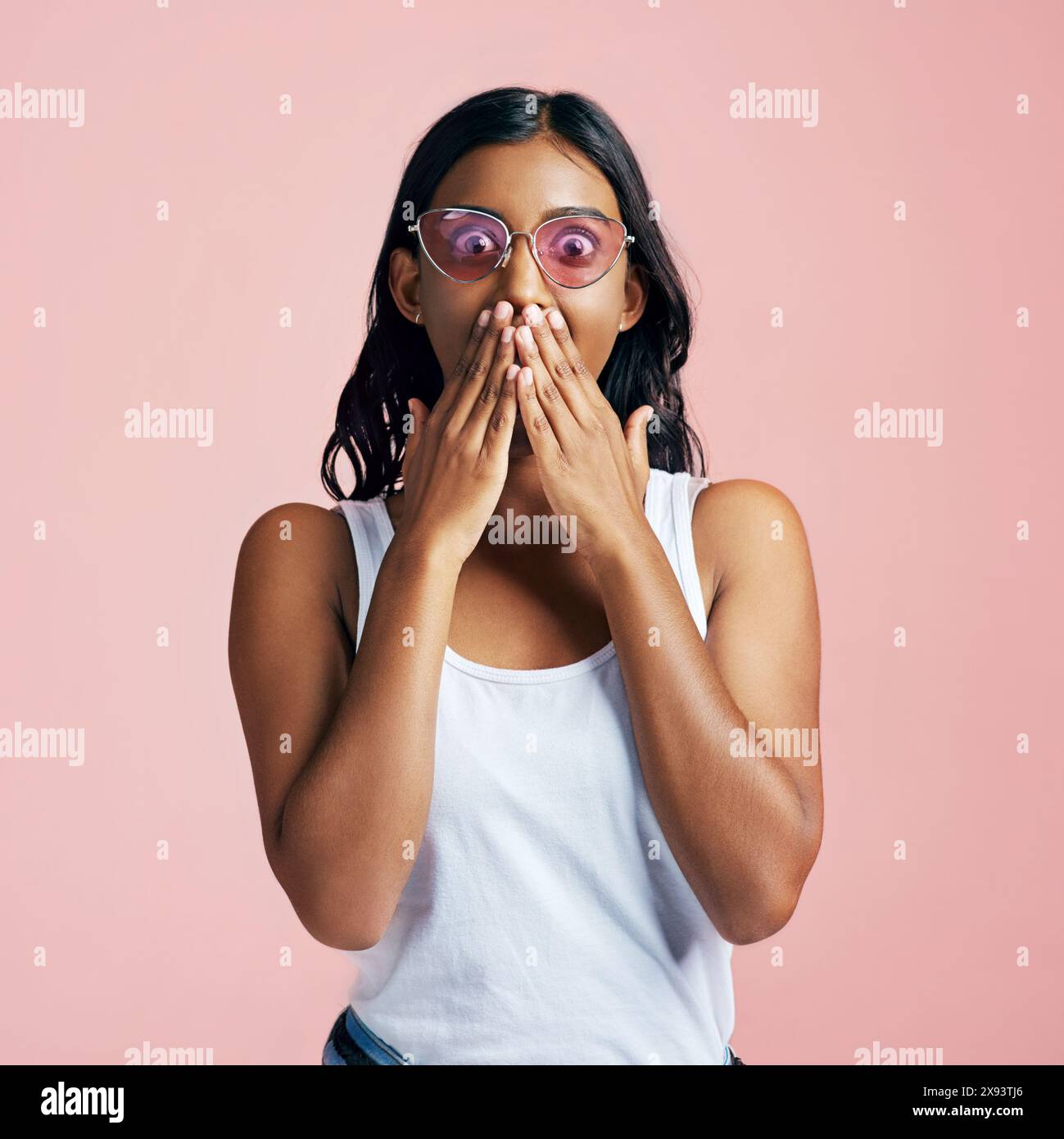 Femme, choquée ou mains pour couvrir la bouche en studio, lunettes de soleil rétro et surprise pour la notification. Personne féminine, fond rose ou wow pour Banque D'Images