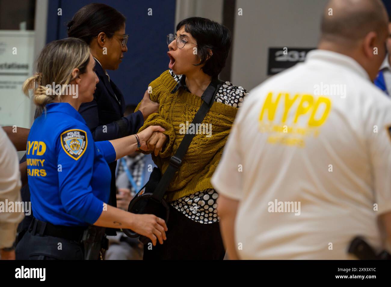 New York, États-Unis. 28 mai 2024. NEW YORK, NEW YORK - MAI 28 : un manifestant est escorté par des policiers du NYPD après avoir interrompu un discours du maire de New York Eric Adams à la Frank Sinatra School of the Arts High School, Astoria, le 28 mai 2024 dans le Queens Borough de New York. Crédit : Ron Adar/Alamy Live News Banque D'Images