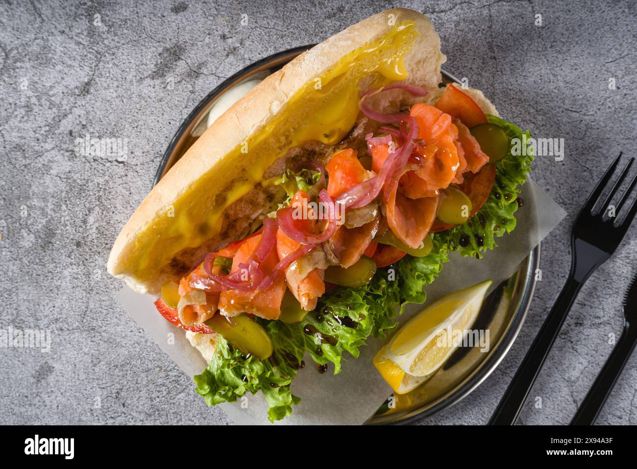 Sandwich au saumon fumé sur plaque métallique sur table en pierre Banque D'Images