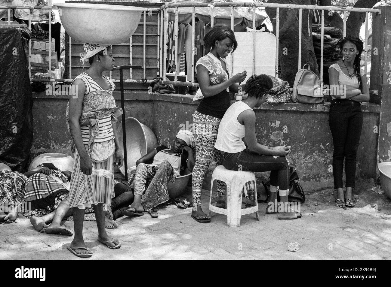 Des femmes et des enfants au Ghana, certains se reposant et d’autres tressant les cheveux, soulignant un moment de communauté et d’activités de la vie quotidienne. Banque D'Images