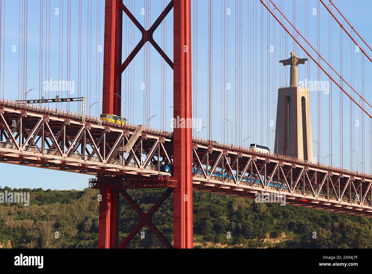 Doubles ponts du pont du 25 avril de Lisbonne, deux autocars traversent le pont supérieur, tandis qu'un train de banlieue Fertagus circule sur le pont inférieur. Banque D'Images