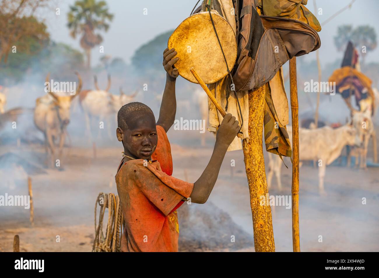 Mundari Boy tambour pour rappeler les vaches, tribu Mundari, Soudan du Sud, Afrique Banque D'Images