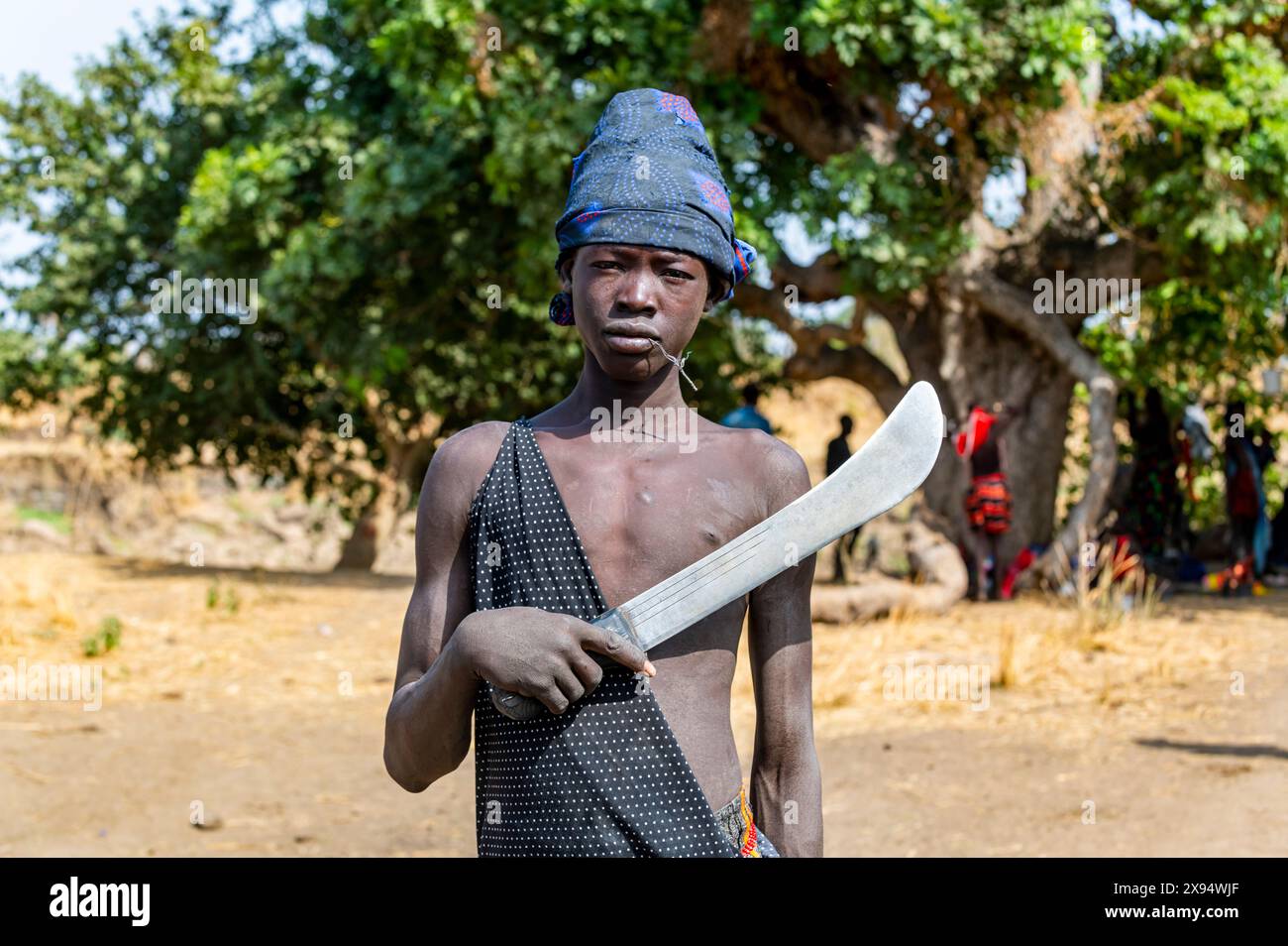 Jeune garçon Mundari tenant une machette, tribu Mundari, Soudan du Sud, Afrique Banque D'Images