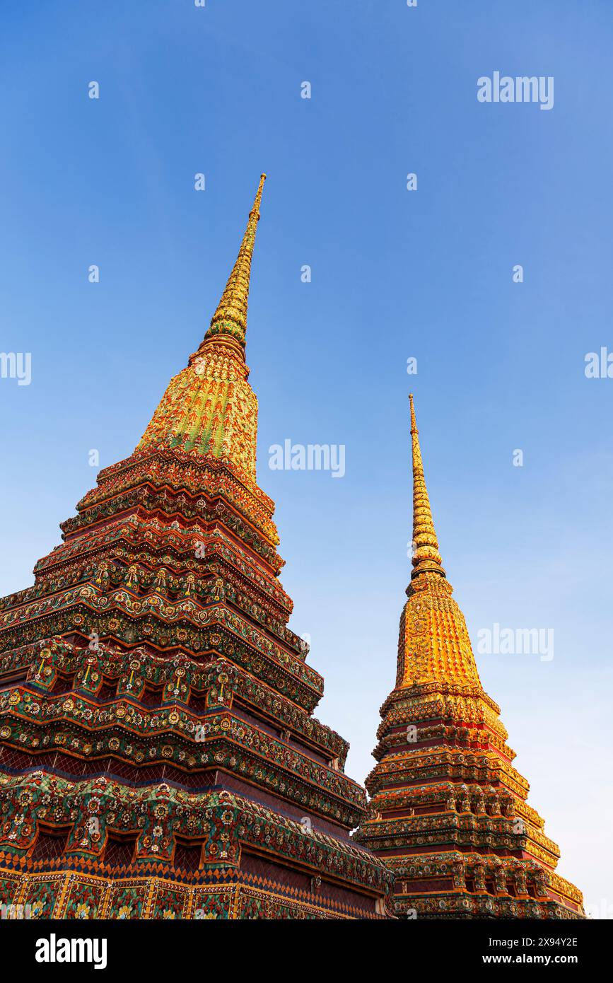 Gros plan de structures de temple ornées (stupa) éclairées au coucher du soleil dans le complexe de temple bouddhiste de Wat Pho (Temple du Bouddha couché), Bangkok Banque D'Images