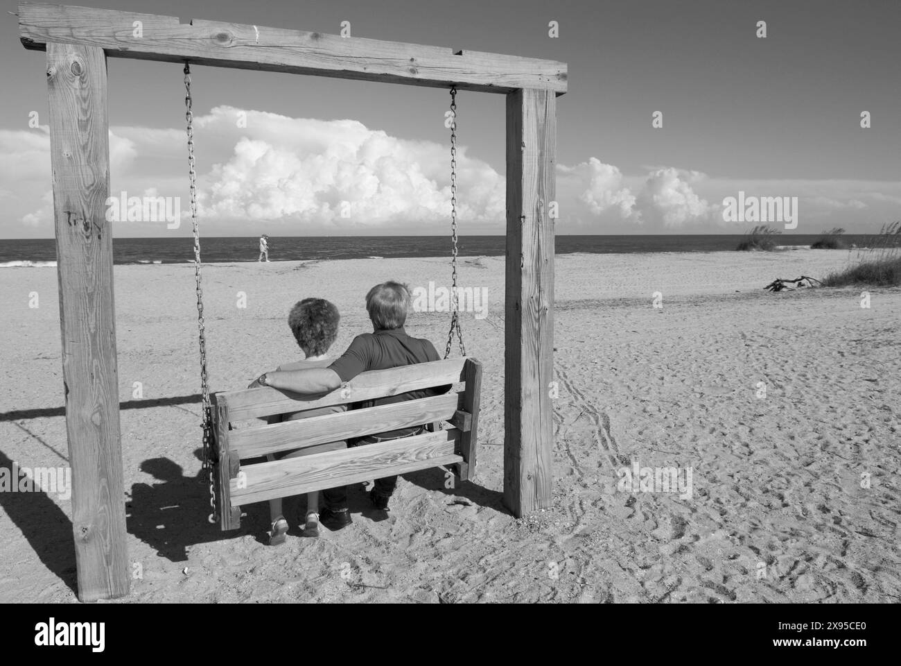 Un couple d'âge moyen se balançant sur une balançoire en bois à la plage de Tybee Island, Géorgie, États-Unis. Banque D'Images