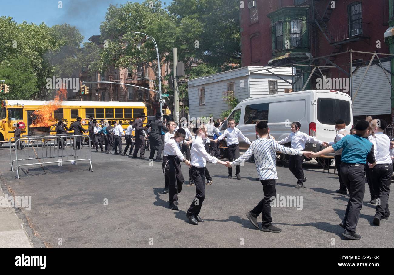 Sur Lag B'Omer 2024, les étudiants de yeshiva célèbrent la joyeuse fête avec un feu de joie et une danse festive, à Brooklyn, New York. Banque D'Images