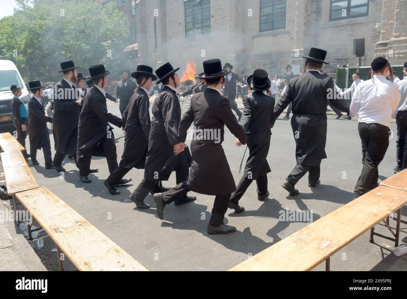 Les étudiants juifs orthodoxes célèbrent Lag B'Omer en dansant près d'un feu traditionnel. Dans une rue fermée à Brooklyn, New York. Banque D'Images